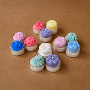 Colorful flower-shaped tealight candles arranged on a brown surface